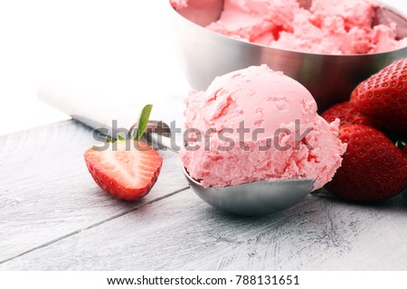 Delicious strawberry ice cream scoop with fresh strawberries on wooden background