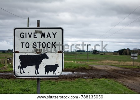 Give way to stock crossing sign with muddy footprints