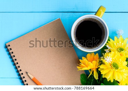 top view coffee cup and notebook on blue wooden table nature background the good morning .decorate flower