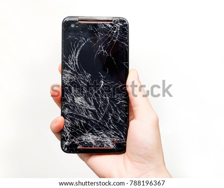 Hand holding black Mobile smartphone with cracked screen isolated on white background