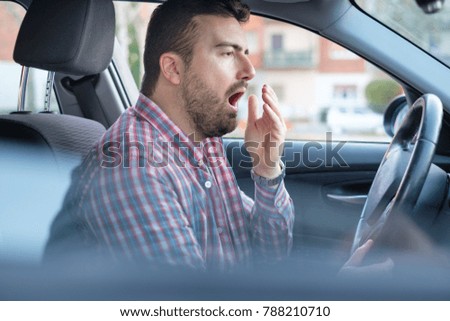 Bored and tired yawning man driving his car need a rest