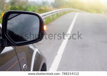 Car on the road trip focus on mirror of car.With turn light.
