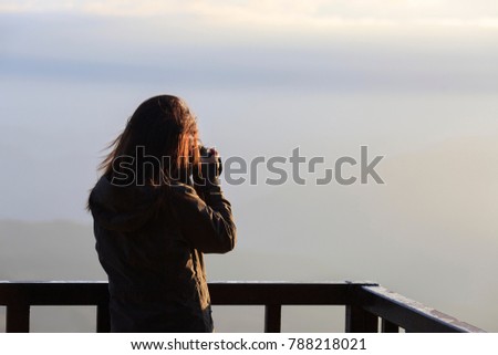 beautiful lady taking landscape photo during light in morning