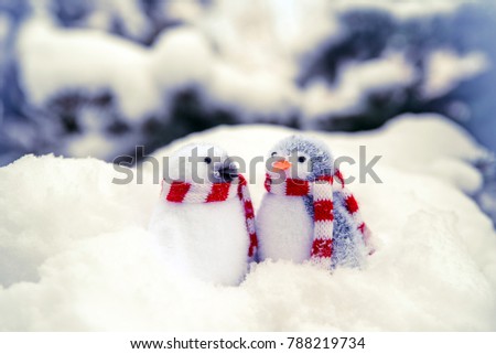 
    Two decorative penguins sit on the snow 