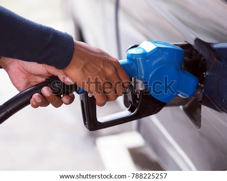 Close up hand of man pumping gasoline fuel in car at gas station. Royalty-Free Stock Photo #788225257