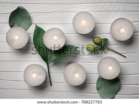 Composition with burning candles on white wooden background