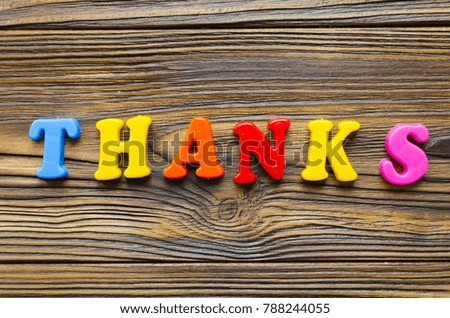  colored text "Thanks" on wooden background