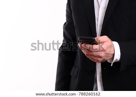 The businessman isolated on white background looks at the smart phone screen.