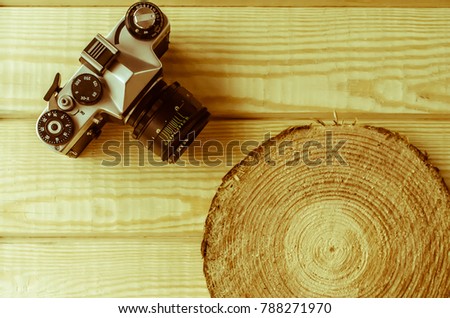 Old retro camera on a wooden background with a blank space for your text or object. Retro-style photo processing.