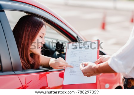 Insurance agent hand over car insurance document to asian woman client in car Royalty-Free Stock Photo #788297359