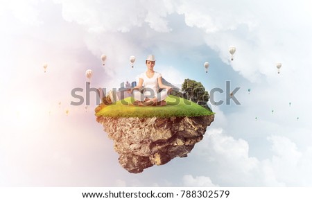 Woman in white clothing keeping eyes closed and looking concentrated while meditating on island in the air with cloudy skyscape and flying aerostats on background. 3D rendering.
