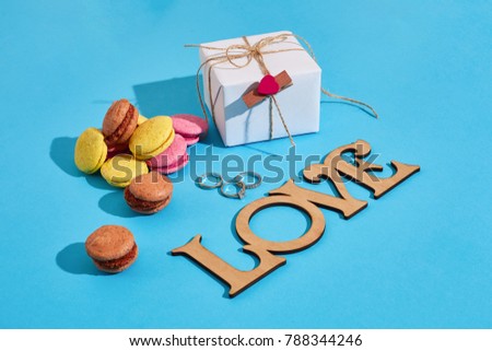 Macaroons and gift box on a blue background with the words I lov