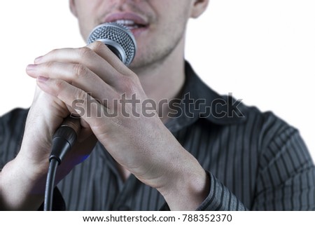 Front view of a man singing to microphone on white background.