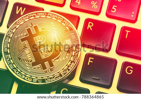 Bitcoin cryptocurrency on laptop keyboard. Close up toned image. Crypto currency - electronic virtual money for web banking and international network payment. Close up image with focus on bitcoin.