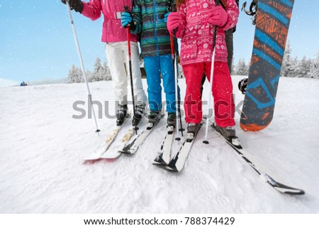 Concept of skis on skiers legs and ski poles on snowy ski terrain