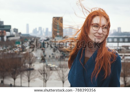 Young woman with red hair in front of New York skyline