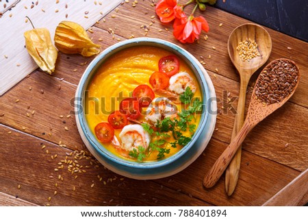 Asian pumpkin soup with shrimps and vegetables.  Royalty-Free Stock Photo #788401894
