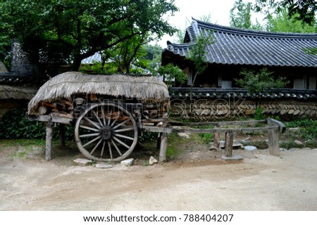 A unique photo from the Korean village. Village home. A cart near the house.