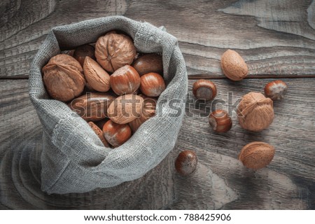 Different types of nuts: walnut, hazelnut, almond and pecan on wooden table, selective focus. Top view