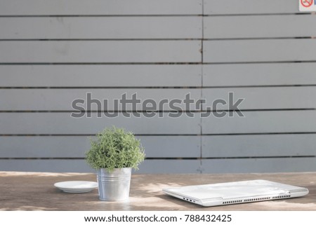 Laptop on desk with flower wood background.
