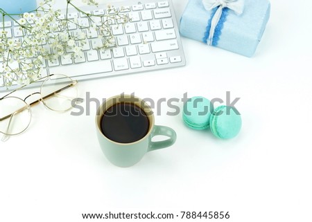 Office feminine desk, workspace with laptop, cup of coffee, macaroons , gift and flowers. Holiday concept. Top view. Copy space