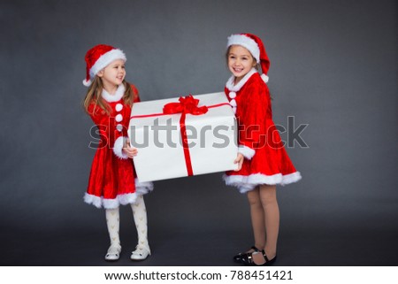 two little girl Santa helpers with big gift box