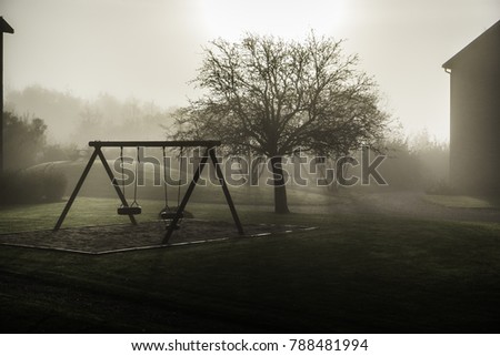 Deserted swingset in the Mist in Sweden Royalty-Free Stock Photo #788481994