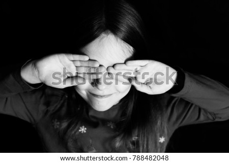 girl playing hide and seek black and white photo