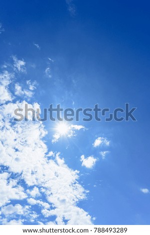 Blue sky with clouds and sun reflection.