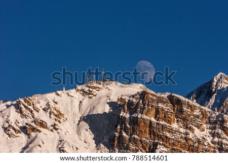 Scenic picture of a big full moon over the Faloria mountain, Cortina D'Ampezzo, Italy