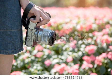 young woman hold the camera in the park