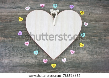 Rustic Wooden Heart and Colorful Candy Hearts Over Wood Background for Valentine's Day Holiday with Copy Space