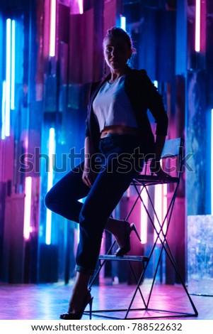 Beautiful modern girl in jacket enjoying a party lifestyle with disco lights.