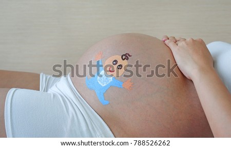 Big tummy of Pregnant woman painted happy baby and headphones.
