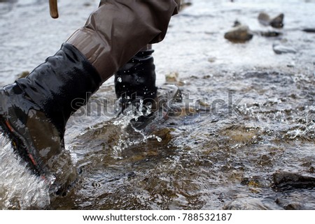 man walking in stream in waders Royalty-Free Stock Photo #788532187