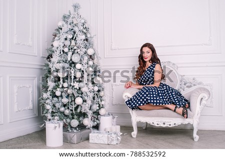 Fashion beautiful brunette woman in dress on white retro studio with Christmas tree