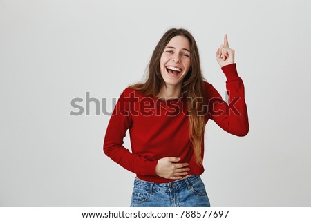 LMAO. LOL. Copy space. Close up of young joyful attractive european girl with long hair in casual stylish outfit laughing on friend's joke, pointing upside, gesticulating with hands Royalty-Free Stock Photo #788577697