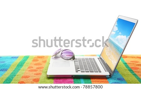 Laptop computer with sun glasses on beach towel .The photo on laptop is mine.