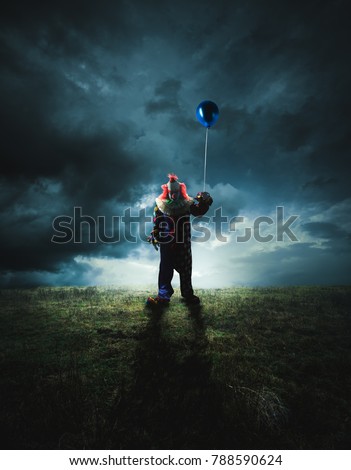High contrast image of a scary clown with a floating balloon on a field