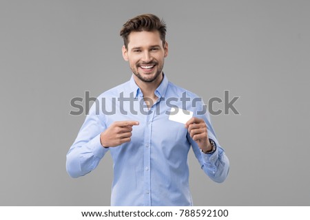 Handsome man in blue shirt  with white card