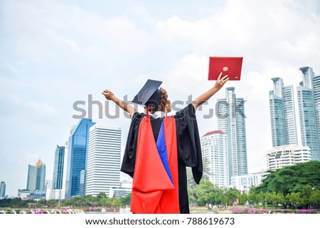 back view of graduate student asian woman hug future and look up to copy space, she wear graduation cap and gown 