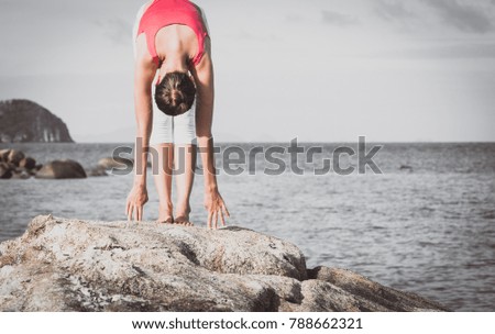 Young woman practice yoga on the stony beach 