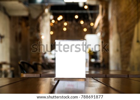 Menu Card Holder with white sheet of paper on table in cafe.Card display Promotion and Information for customer,Picture stand,Sign Holder and Photo Frame template.