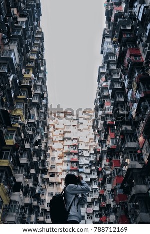 Young woman taking photo with her camera of building at in Hong Kong