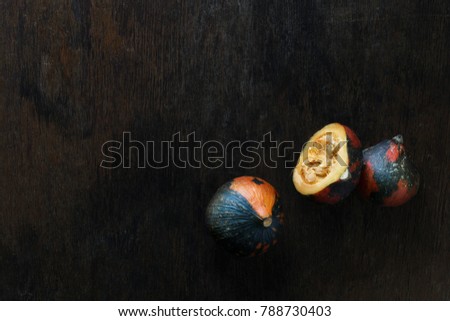 Ð¡olored pumpkin slices on a dark wooden table with copy space, top view