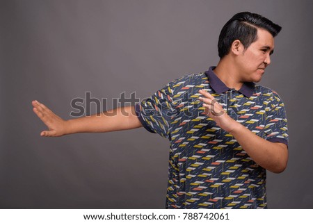 Studio shot of young multi-ethnic man against gray background
