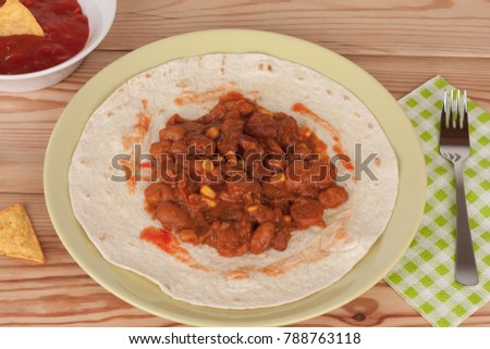 Chili Con Carne on tortilla wrap with salsa sauce and tortilla chips