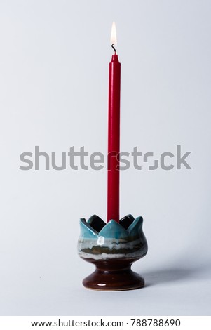 
Red candle and fire on white background.