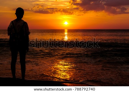 A girl locking the sunset on the beach ,sunset seascape ,hope for the life concept,lowlights picture
