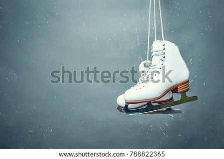Figure skates are suspended against the background